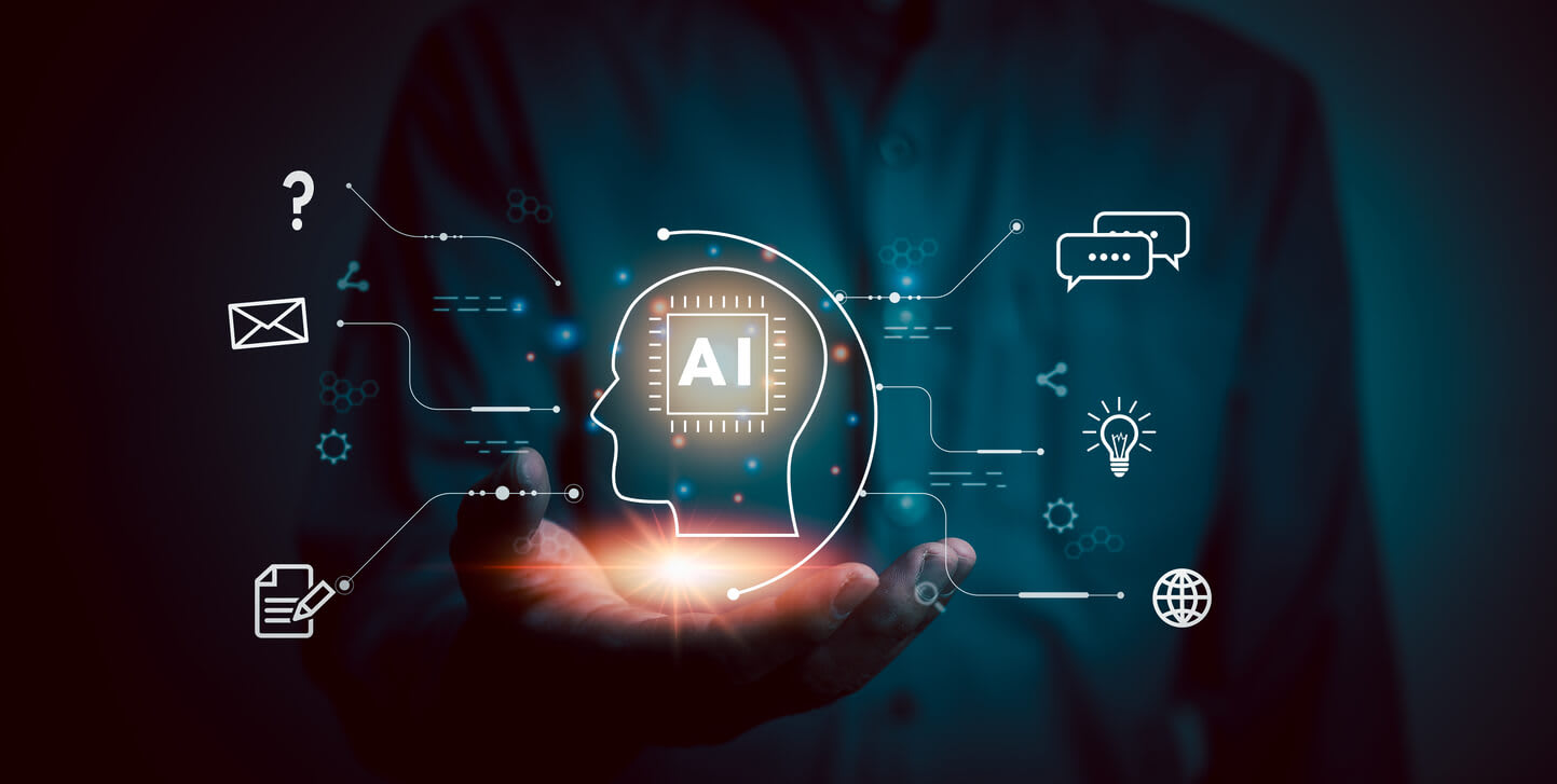 An image of a person holding a icon of a head with a microchip and the word AI inside it, with technology icons surrounding it to symbolise AI-based machine monitoring systems.