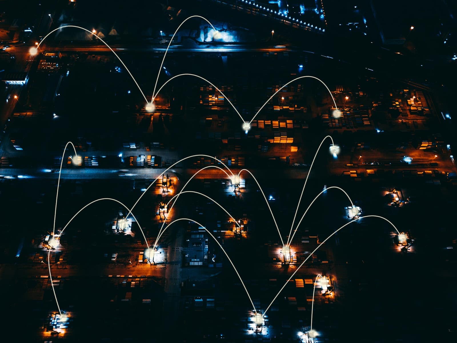 Night aerial view of a shipping port with digital connectivity lines, representing 5G integration in smart supply chain management.