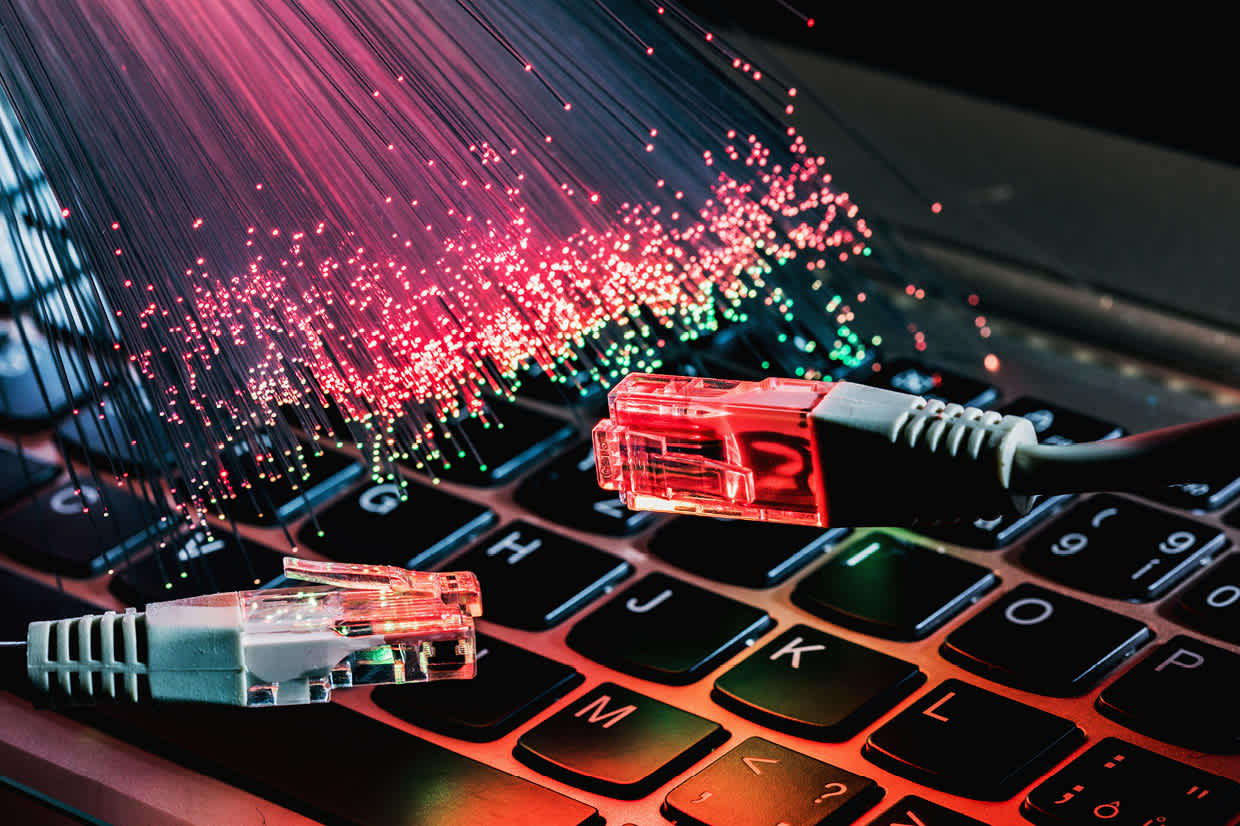 Network cables and fiber-optic data streams over a keyboard, representing wireless IoT connectivity technologies such as LoRaWAN, NB-IoT, and Sigfox.