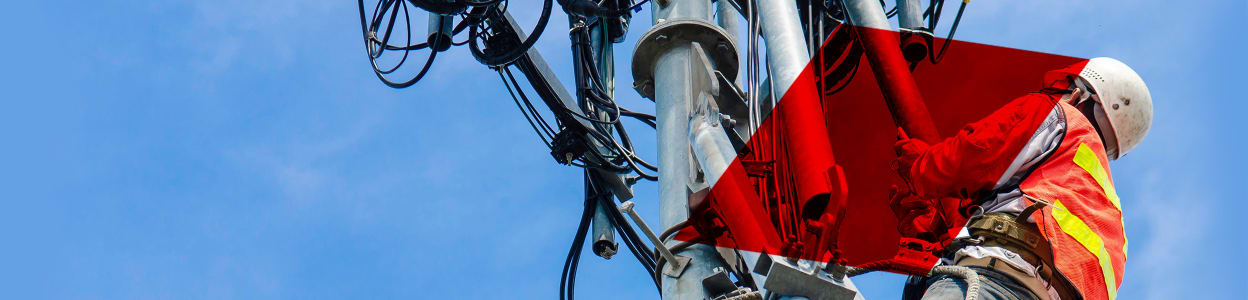 Telecom engineer climbing up an electricity pylon