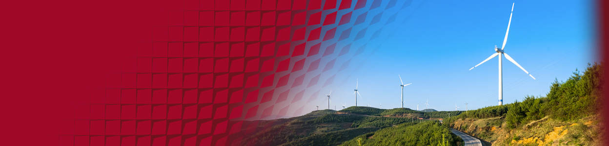 A road winding through green hills with multiple wind turbines generating renewable electricity.