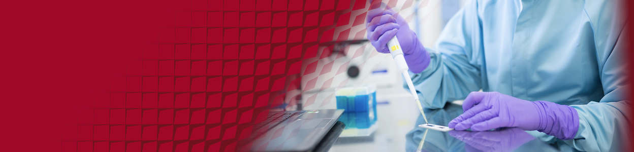 A scientist wearing protective equipment, using a pipette in a sterile labaratory.