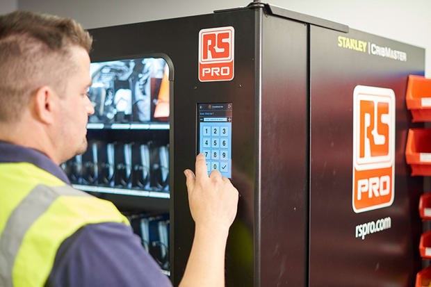 Funcionário a tirar um produto de uma máquina vending industrial VendStock®.