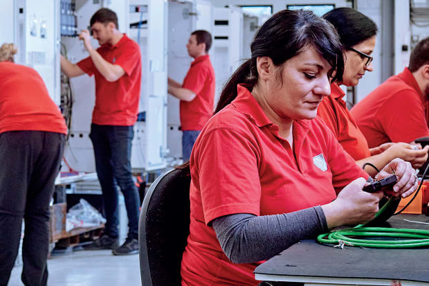 employees working at stations in manufacturer