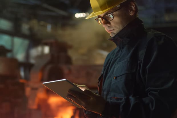 male engineer with hard hat and tablet PC on site