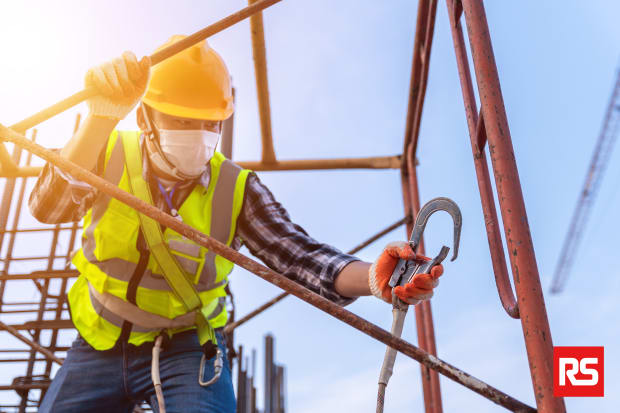 Travailleur en hauteur avec ses EPI : gilet jaune, casque, masque et harnais