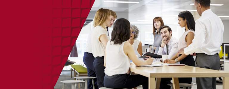 Colleagues discussing a Lean Six Sigma process improvement project in an office