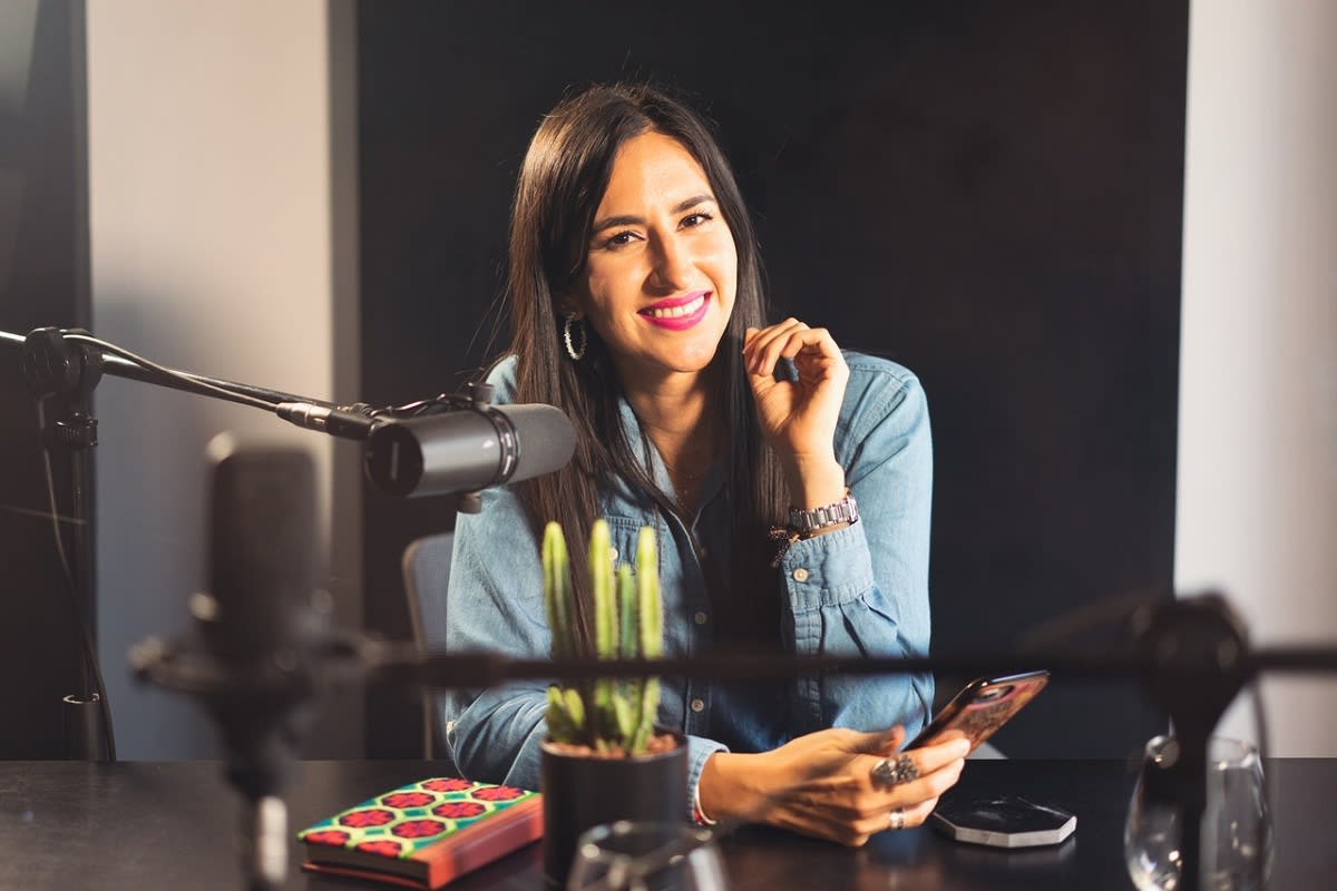 woman in front a podcasting mic