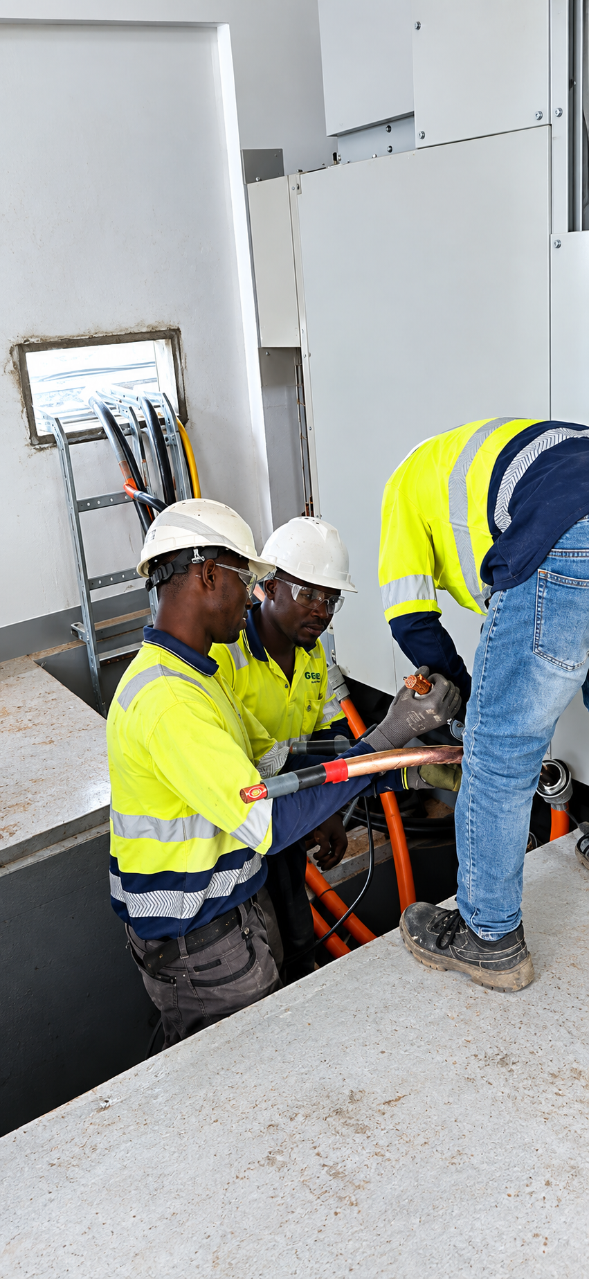 A team of engineers in hard hats reviewing blueprints on a construction site