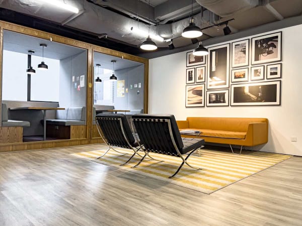 Modern coworking space with stylish seating, warm lighting, and a chic gallery wall.