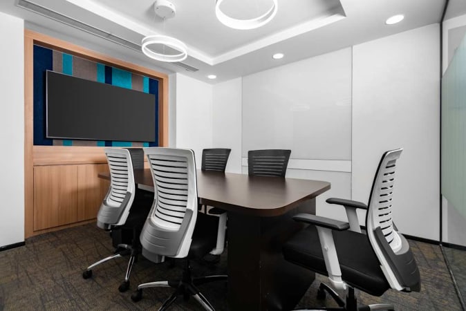 Modern meeting room with sleek chairs, smart TV, and ambient lighting for productive sessions.