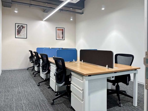 Modern coworking space featuring ergonomic chairs, shared desks, and bright lighting in Noida.