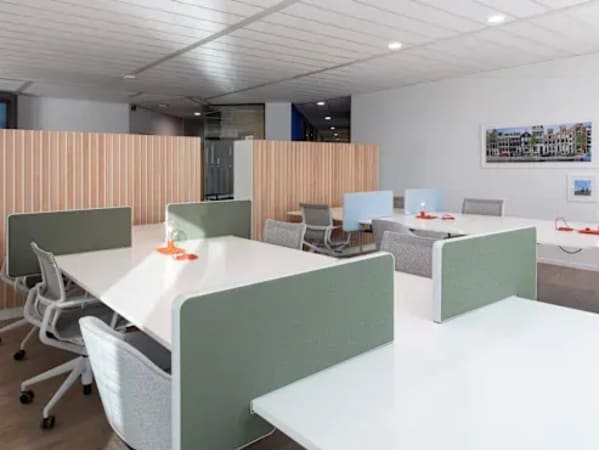 Modern coworking space featuring ergonomic chairs, spacious desks, and contemporary decor.