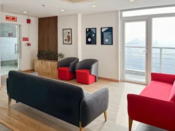 Bright coworking lounge with modern seating, natural light, and artistic decor in Haryana.