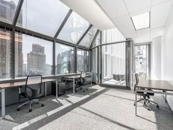 Bright, modern coworking space with city views, ergonomic seating, and abundant natural light.