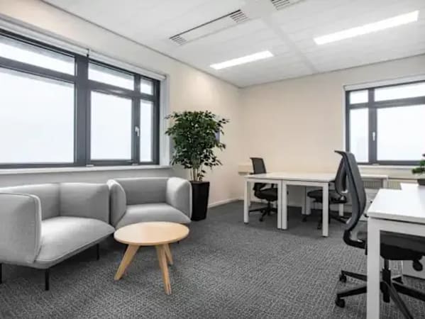 Modern coworking space in Indra Puri Colony featuring bright windows and versatile seating.