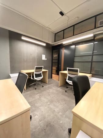 Modern coworking space with ample natural light, ergonomic chairs, and sleek desks.