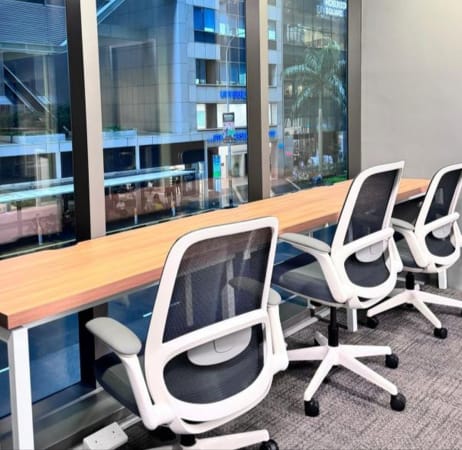 Modern coworking space with ergonomic chairs and large windows offering city views.