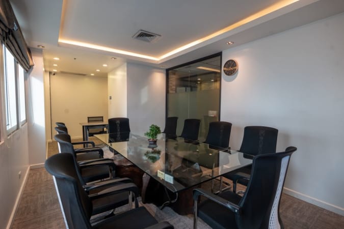 Modern conference room with glass table, ergonomic chairs, and natural light in Quezon City.