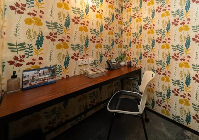 Cozy workspace with vibrant decor, equipped desk, and ergonomic chair. Ideal for focused productivity.