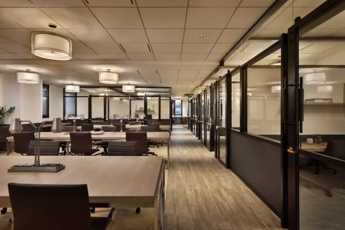 Modern coworking space with sleek desks, ample natural light, and private meeting rooms.