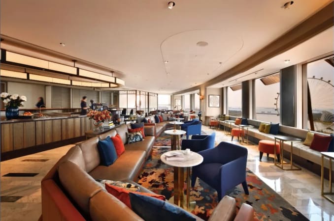 Elegant coworking space with plush seating, vibrant decor, and panoramic city views.