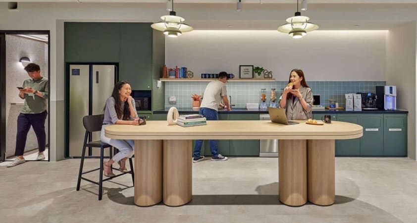 Modern coworking space with a stylish kitchen and collaborative seating. Ideal for networking.