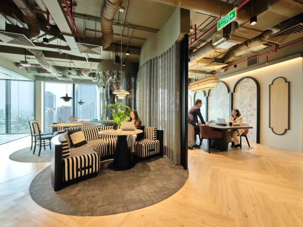 Stylish coworking space with modern design, natural light, and versatile seating options.