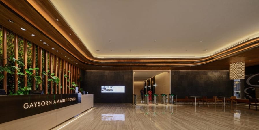 Elegant coworking lobby with modern design and lush greenery in Thanon Phloen Chit.
