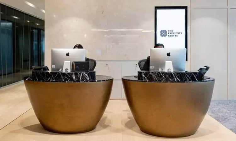 Modern reception with sleek marble and gold design, perfect for a professional coworking space.