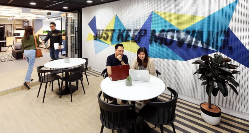 Vibrant coworking area with modern décor, collaborative seating, and motivational wall art.