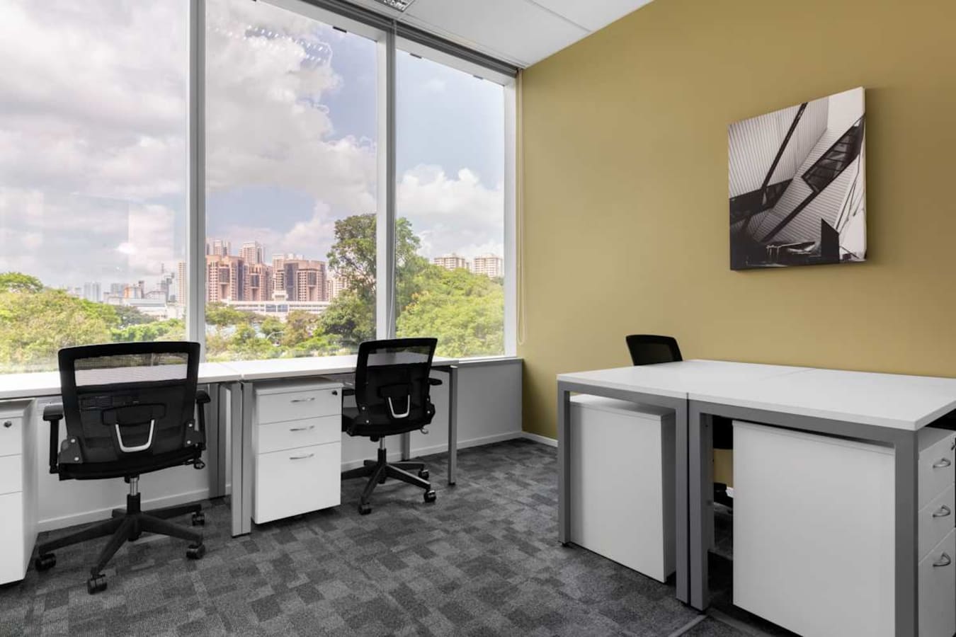 Bright coworking space with modern desks, ergonomic chairs, and a scenic city view.