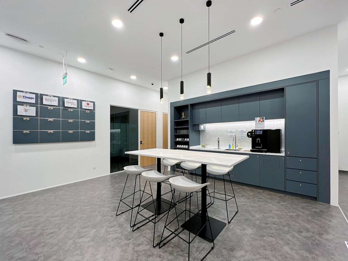 Modern coworking kitchen on Robinson Road, equipped with sleek cabinetry and ample seating.