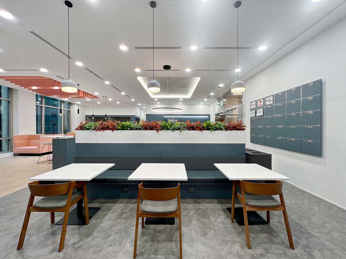 Modern coworking space with sleek tables, contemporary lighting, and greenery accents on Robinson Road.