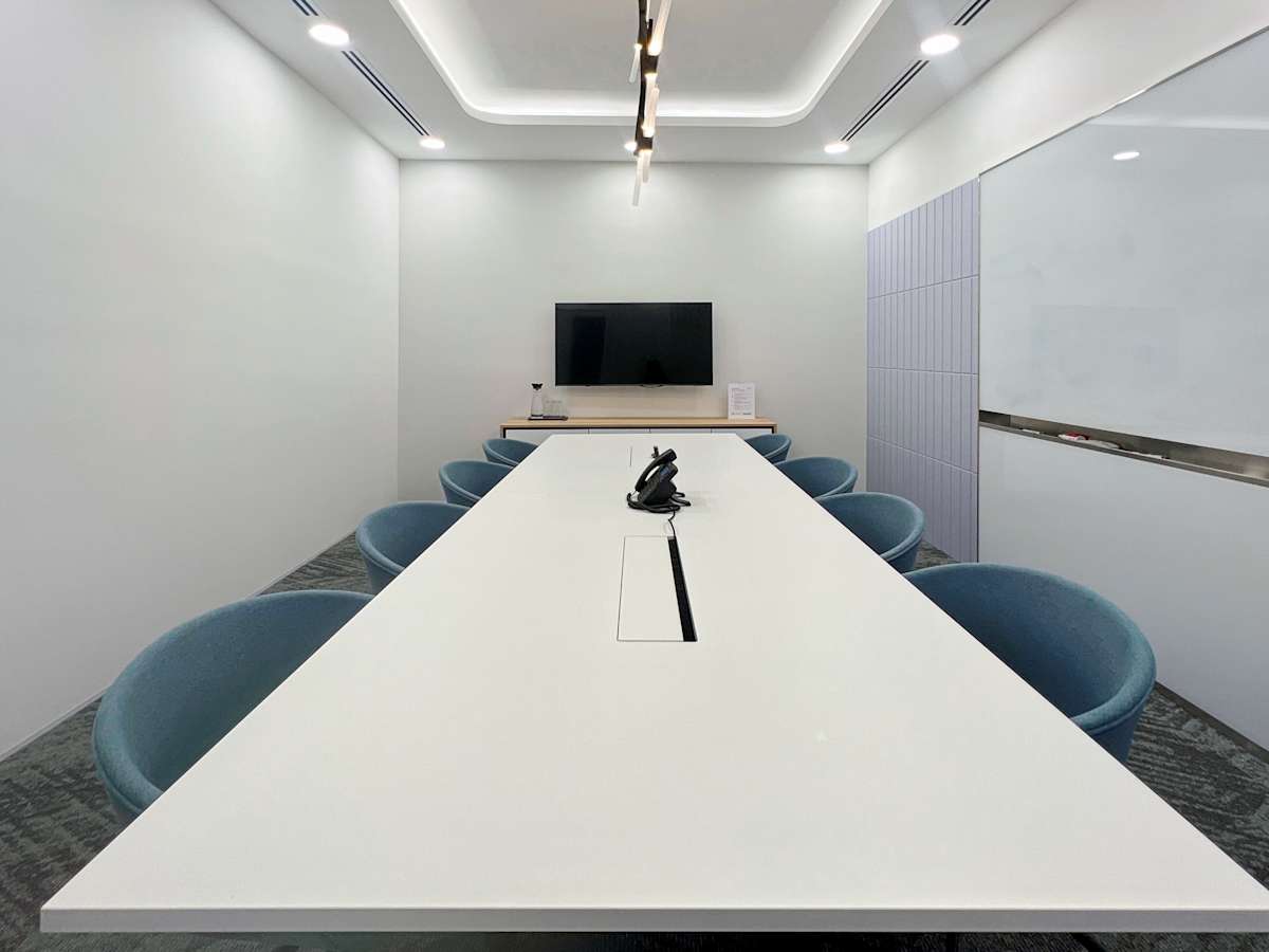 Modern meeting room with sleek table, comfortable chairs, and advanced AV setup on Robinson Road.