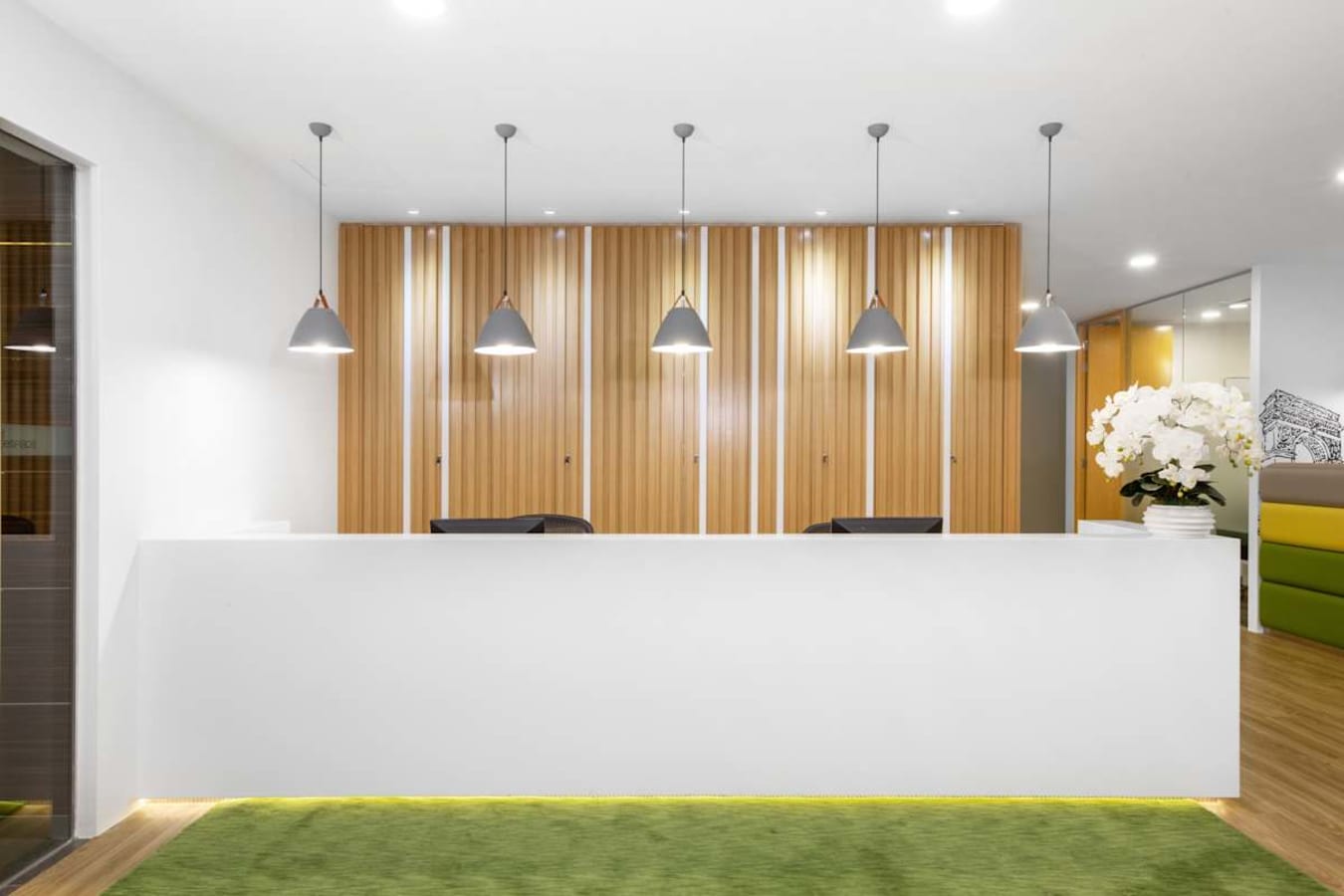 Modern coworking reception with sleek design in Raffles Place, featuring wood accents and ambient lighting.