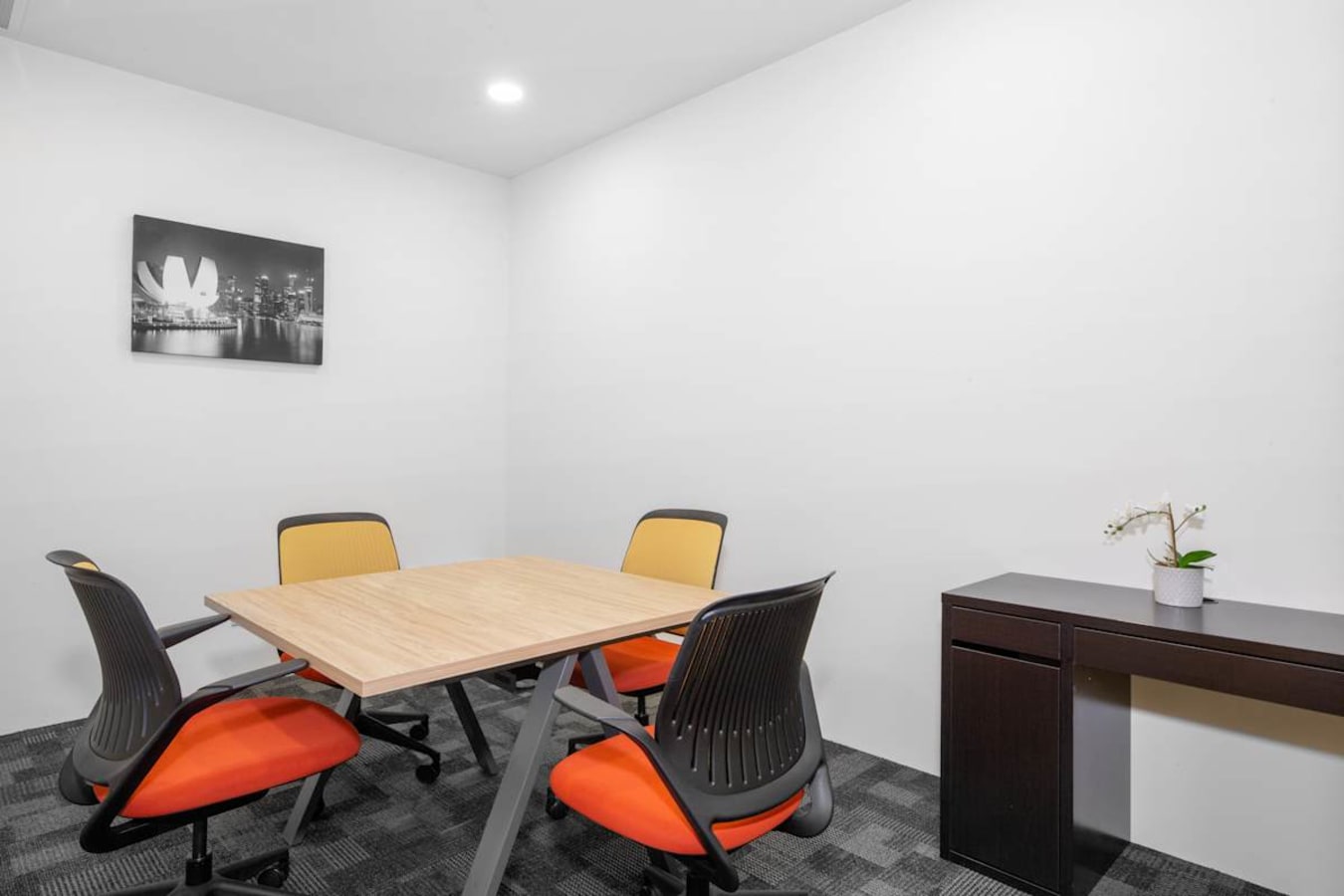 Modern meeting room with ergonomic chairs and minimalist decor, ideal for flexible work.