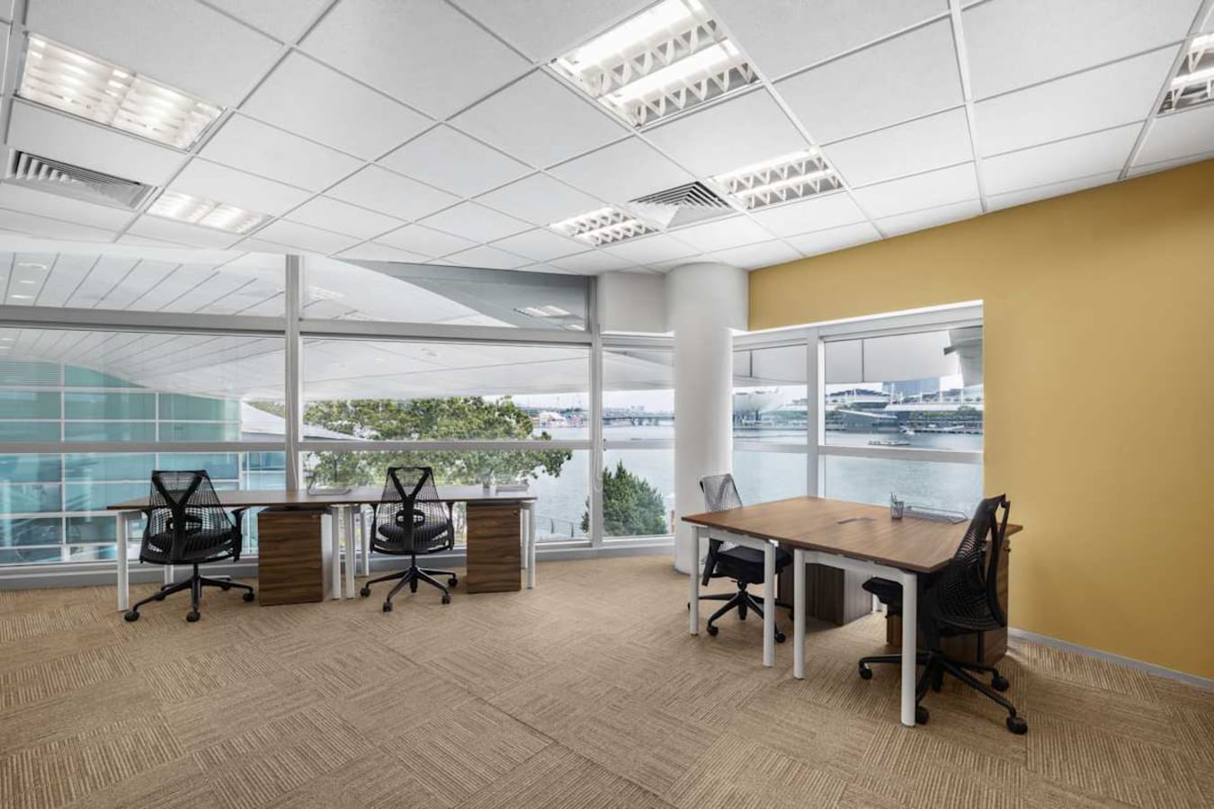 Bright coworking space with waterfront views, modern desks, and ergonomic chairs in Fullerton Road.