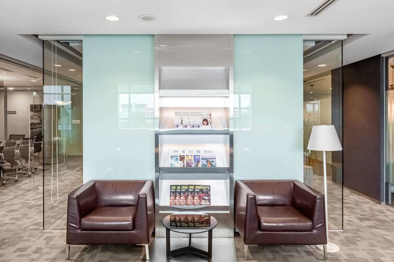 Modern coworking lounge with leather chairs, glass accents, and ambient lighting in Tampines Ave 5.