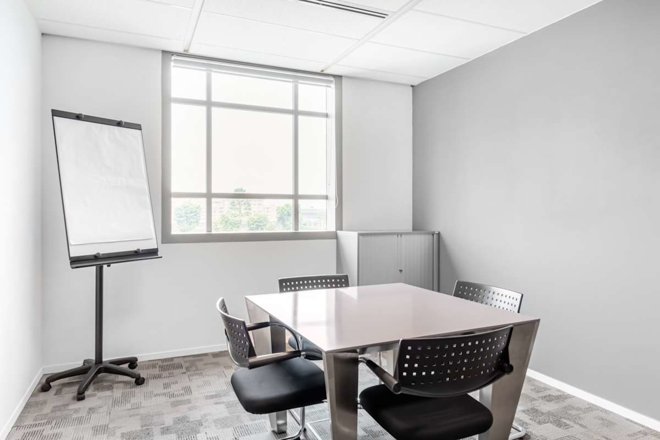 Bright, modern meeting room with natural light and sleek furnishings in Tampines coworking space.