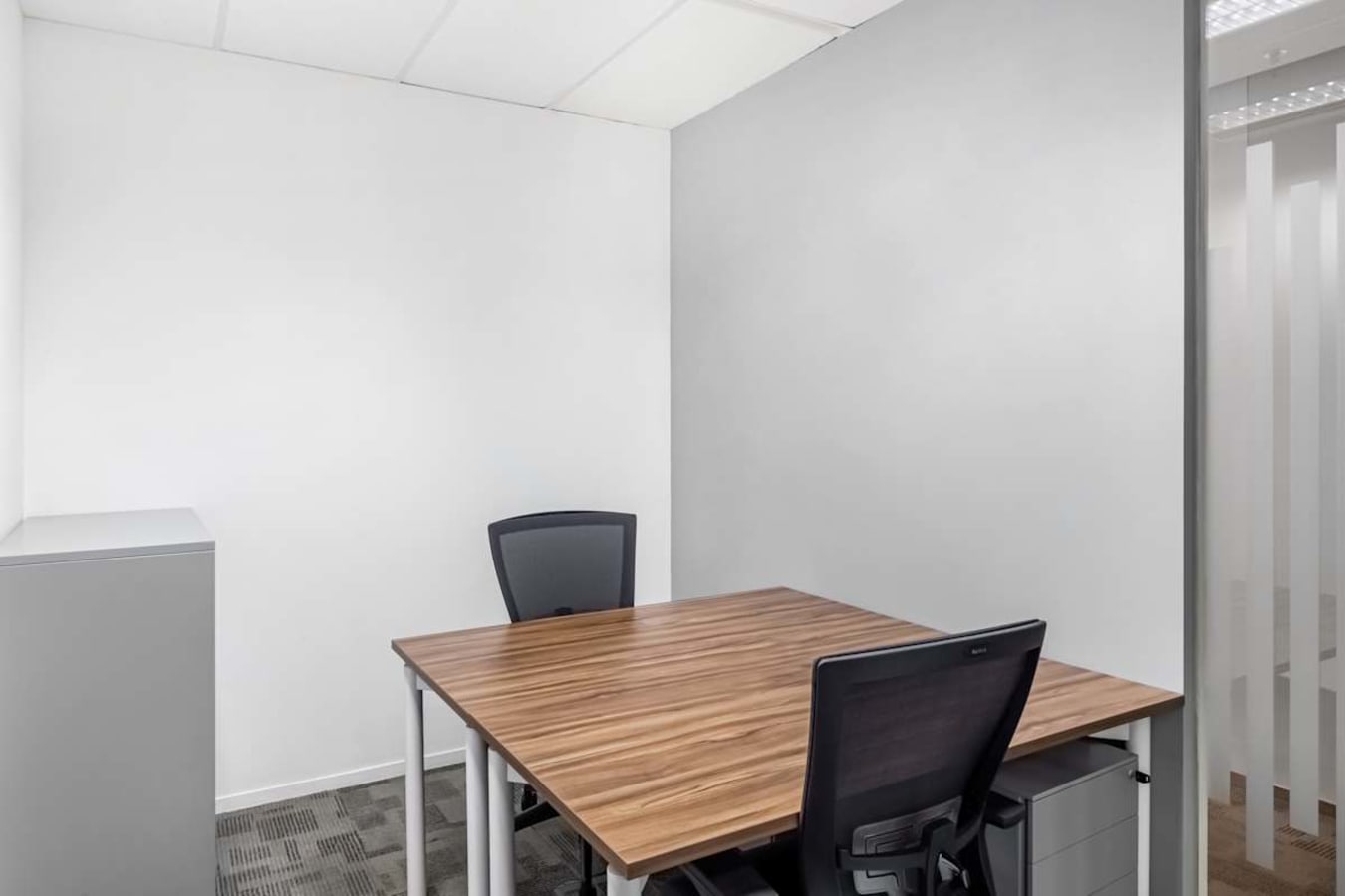 Modern private office with sleek wood desk and ergonomic chairs in Tampines Ave 5 coworking space.