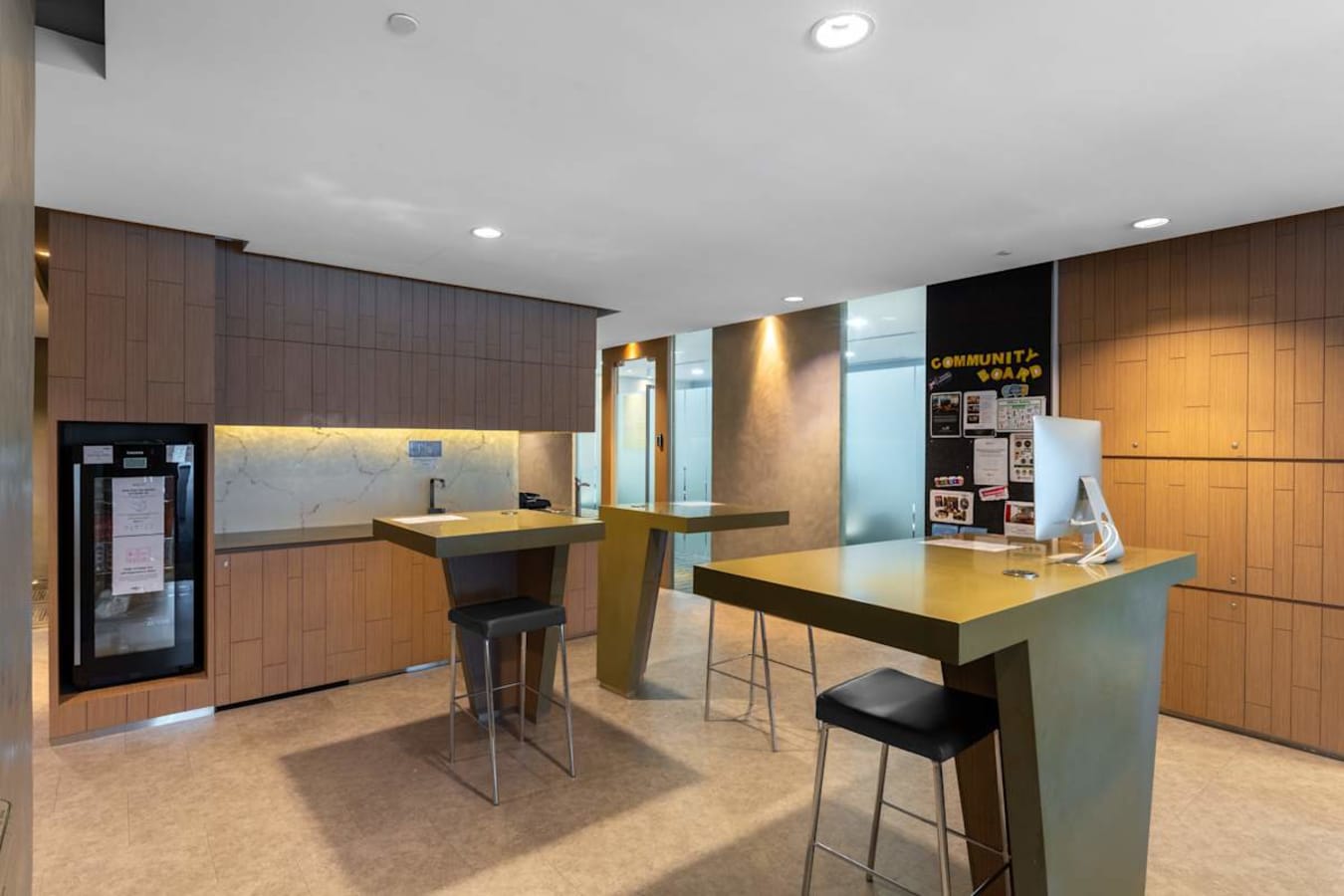 Modern coworking space with stylish tall tables, ample natural light, and a relaxed atmosphere.