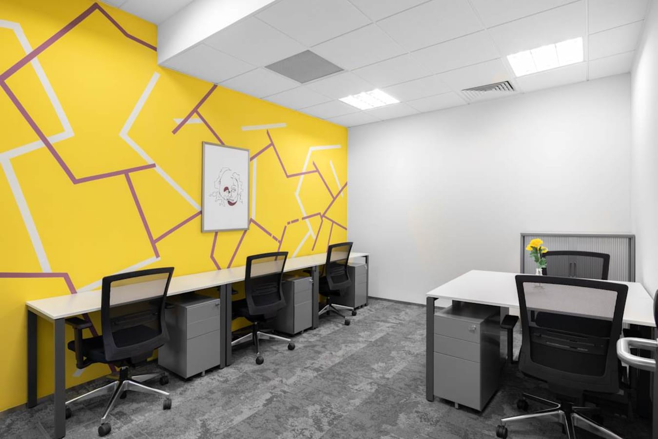 Bright coworking space on Venture Drive with modern desks, vibrant decor, and ample lighting.