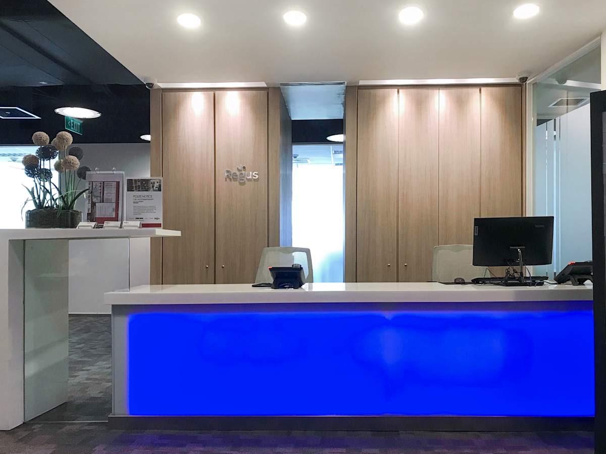 Modern coworking space featuring a sleek reception area with ambient lighting and stylish decor.