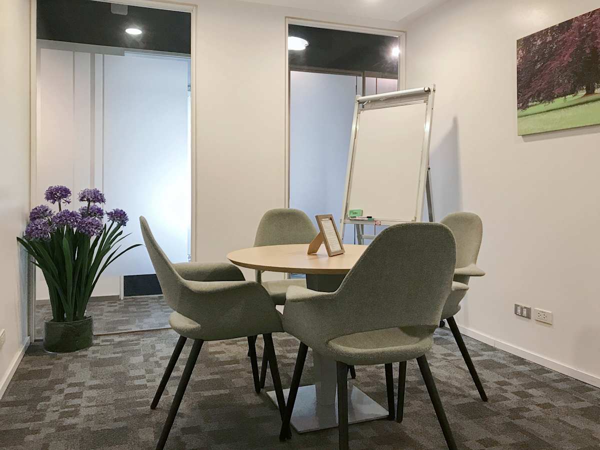 Bright meeting room with comfortable seating, a large whiteboard, and modern decor. Ideal for collaboration.