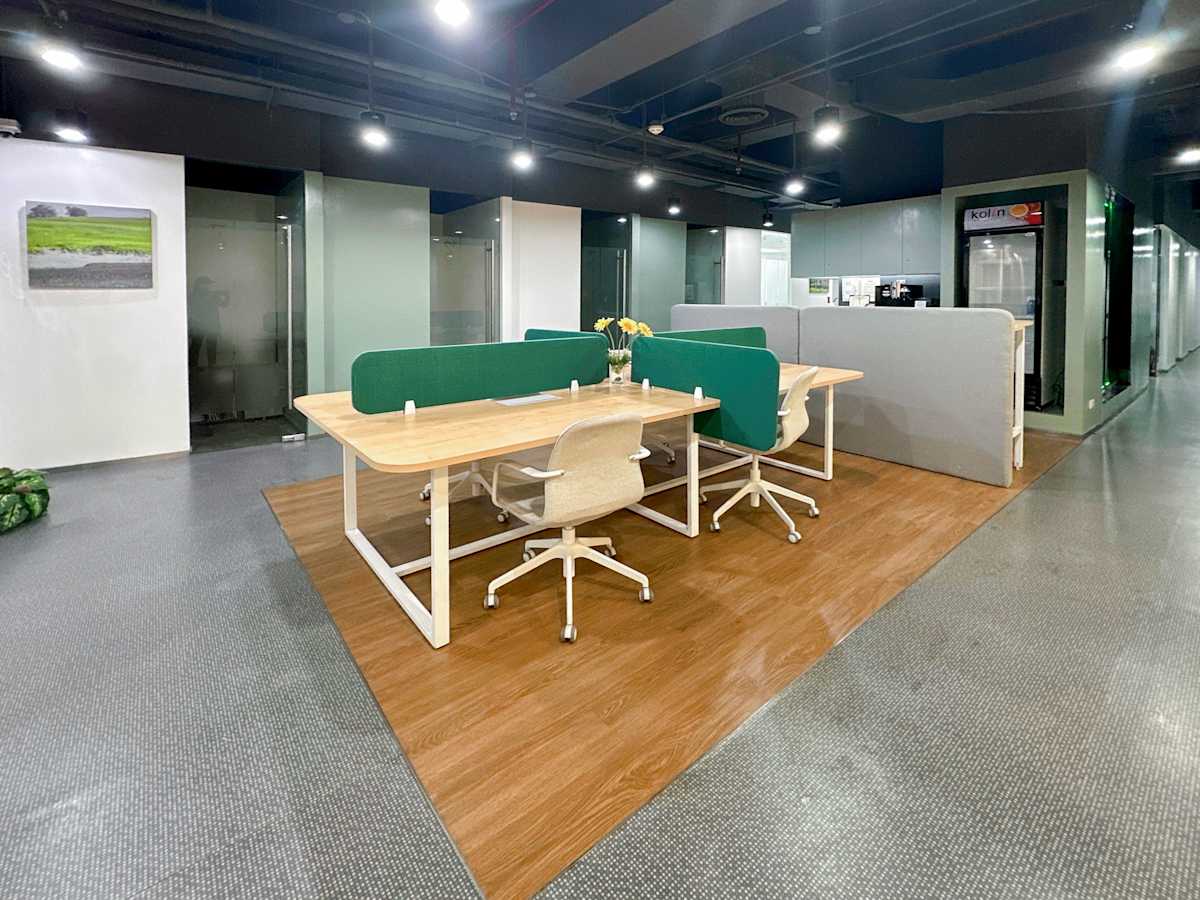 Sleek coworking space with modern workstations, bright lighting, and private meeting areas.