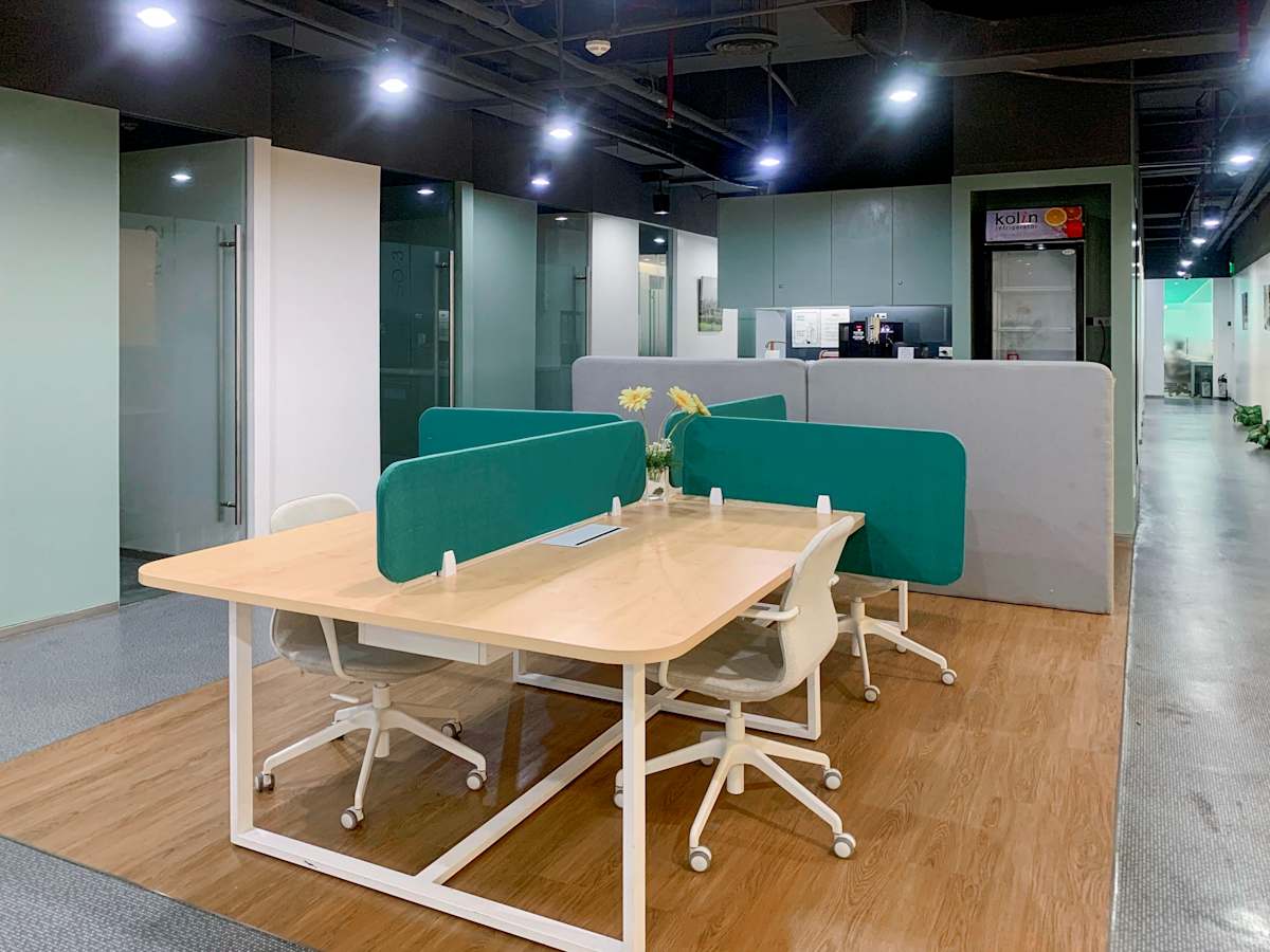 Modern coworking space with shared desks, ergonomic chairs, and stylish dividers.