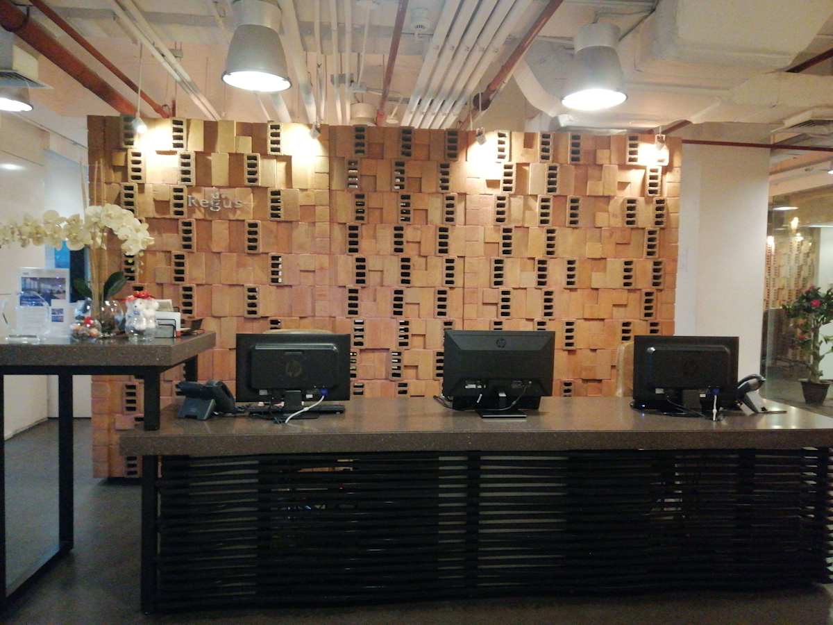 Modern reception area with wood accents and ample workspace, ideal for coworking needs.