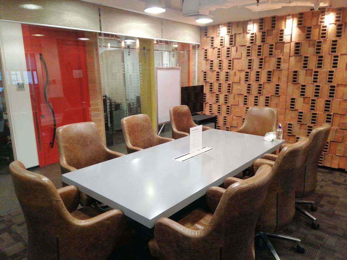 Modern meeting room with sleek table, leather chairs, and creative wall design. Ideal for collaboration.