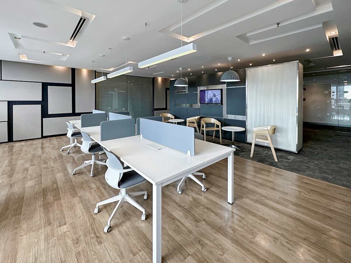 Modern coworking space with sleek desks, ample lighting, and collaborative meeting areas.
